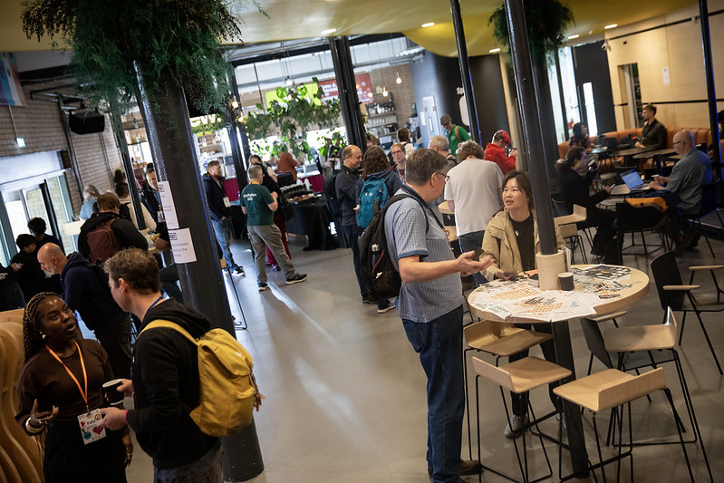 A view of the lower foyer at Contact Theatre, with PyCon UK attendees engaged in conversation.