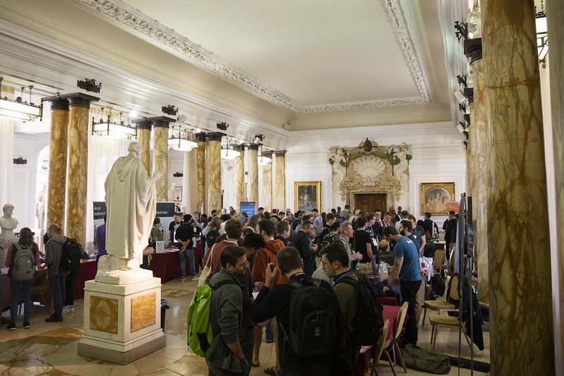 Looking down hall in Cardiff City Hall with tables along either side. The tables have branding from various companies.