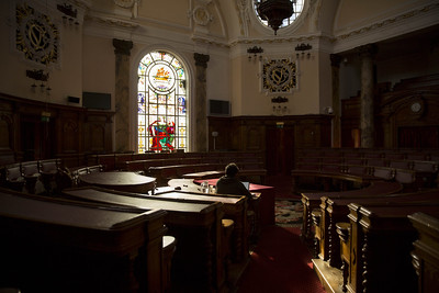 Looking towards the centre of a circular room in Cardiff City Hall with raked seating.