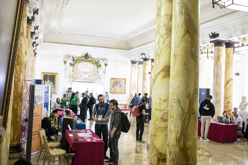 Looking down hall in Cardiff City Hall with tables along either side. The tables have branding from various companies.